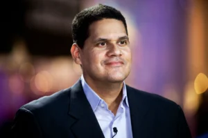 Reggie Fils-Aimé Didn't Try to Beat Nintendo's Rivals. He Changed the Game Nobody thought Nintendo needed reinventing. Not really. When Reggie Fils-Aimé joined Nintendo of America in 2004, the company was falling behind fast. Sony's PlayStation 2 and Microsoft's Xbox owned the console market. The GameCube had moved about 21.7 million units worldwide. The PS2? Over 155 million. Not even close. Everyone assumed the answer was obvious: build something more powerful, go head-to-head on specs. Fils-Aimé didn't buy it. He thought Nintendo's real opportunity was people who never called themselves gamers in the first place. Forget chasing rivals on horsepower. Grow the audience instead. It was a real gamble. If it flopped, Nintendo could've slid even further behind. It didn't flop. It set up the Wii's massive breakout. The Bet: Give Away the Thing That Explains the Thing Before the Wii launched in 2006, Fils-Aimé pushed hard for one idea: pack Wii Sports in the box, free. Iwata said no at first. Nintendo had always treated its games as premium products, moneymakers in their own right. Giving one away meant walking away from serious revenue. But Fils-Aimé wasn't thinking about generosity. He was thinking about acquisition. His own words later: "The goal of Wii is to expand gaming from its current niche to a mass-market medium." Nintendo eventually caved and bundled it in the Americas. The results speak for themselves. Wii sold 101.63 million units worldwide, dwarfing the GameCube's 21.74 million. Wii Sports, riding that bundle, reached at least 82.79 million copies. The real lesson here isn't just "give stuff away." It's sharper than that. Sometimes a product's biggest value isn't in selling it. It's in using it to kill the customer's doubt about something else. Three Rules Behind Reggie's Decisions Expand the category instead of fighting over it. While everyone else polished the existing game, Reggie asked who else could be playing. "You have to pursue new innovative ideas that break the mold." The Wii went after families, older adults, casual players — not the graphics-chasing core crowd. Still unmistakably Nintendo, just reaching further. Make the innovation explain itself. A great product still dies if nobody can explain why it matters in one sentence. Nintendo's goal: make it "crystal clear what the proposition is." That's exactly why the Switch got pitched so simply — a home console you can take anywhere. Clean. No confusion, unlike what happened with the Wii U. Treat failure as research. Find the exact assumption that broke. Then rebuild around it. The Wii U had two problems: nobody understood what it was for, and there wasn't enough great software to keep people playing. Nintendo tackled both head-on with Switch. The $100 Million Idea That Became a 13.56 Million-Unit Warning The Wii U was the cautionary tale nobody talks about enough. After the Wii's 101.63 million in sales, Wii U limped to just 13.56 million. Fils-Aimé later admitted where it went wrong — positioning was muddy, and the software pipeline dried up. But Nintendo didn't scrap the idea. It fixed it. Switch kept the off-TV flexibility Wii U tried to offer, but made the portability the whole point, impossible to miss. By June 30, 2026, Switch had sold 156.59 million units worldwide. Fils-Aimé helped get it off the ground, though most of that success came after his 2019 retirement. The Network Behind the Contrarian Iwata and Miyamoto brought the institutional weight and creative firepower — though both pushed back on the Wii Sports idea at first. NOA executive Mike Fukuda backed Fils-Aimé up when it mattered, during negotiations. Doug Bowser took over as Nintendo of America president when Fils-Aimé retired in 2019. His real edge, though? Position. He sat right between American consumers, retailers, and Nintendo's leadership in Kyoto. Less a lone genius, more a translator — someone who could turn what he saw in the market into strategy Kyoto would actually listen to. The Move to Copy: Bundle the Proof Ask yourself one question: What could a customer experience in five minutes that makes the rest of your pitch pointless? Whatever that is — build your demo, your trial, your onboarding, your bundle around it. Don't rush to squeeze maximum revenue out of that layer. Instead, test whether giving up some margin there pays off in conversions, retention, or a bigger market overall.
